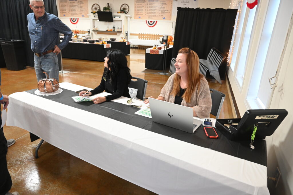 Attendees at conference table checking in guests for Saturday breakfast