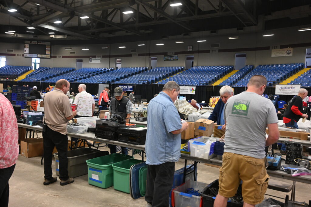 Attendees buying and selling ham radio equipment at tables