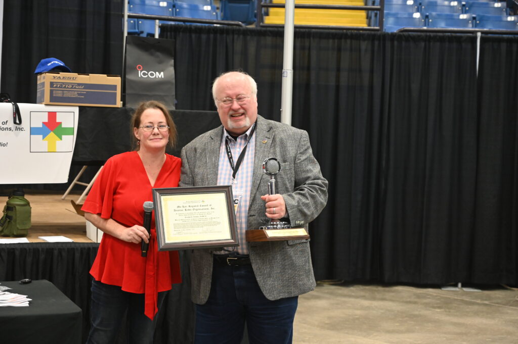 Two event attendees posing with an award